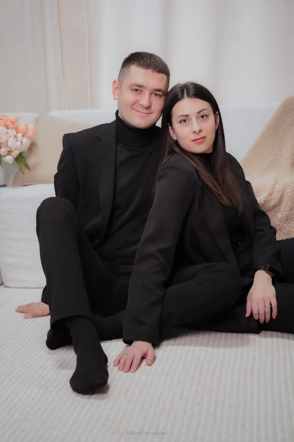Alexandra și Dumitru în ținute negre, așezați împreună în studio