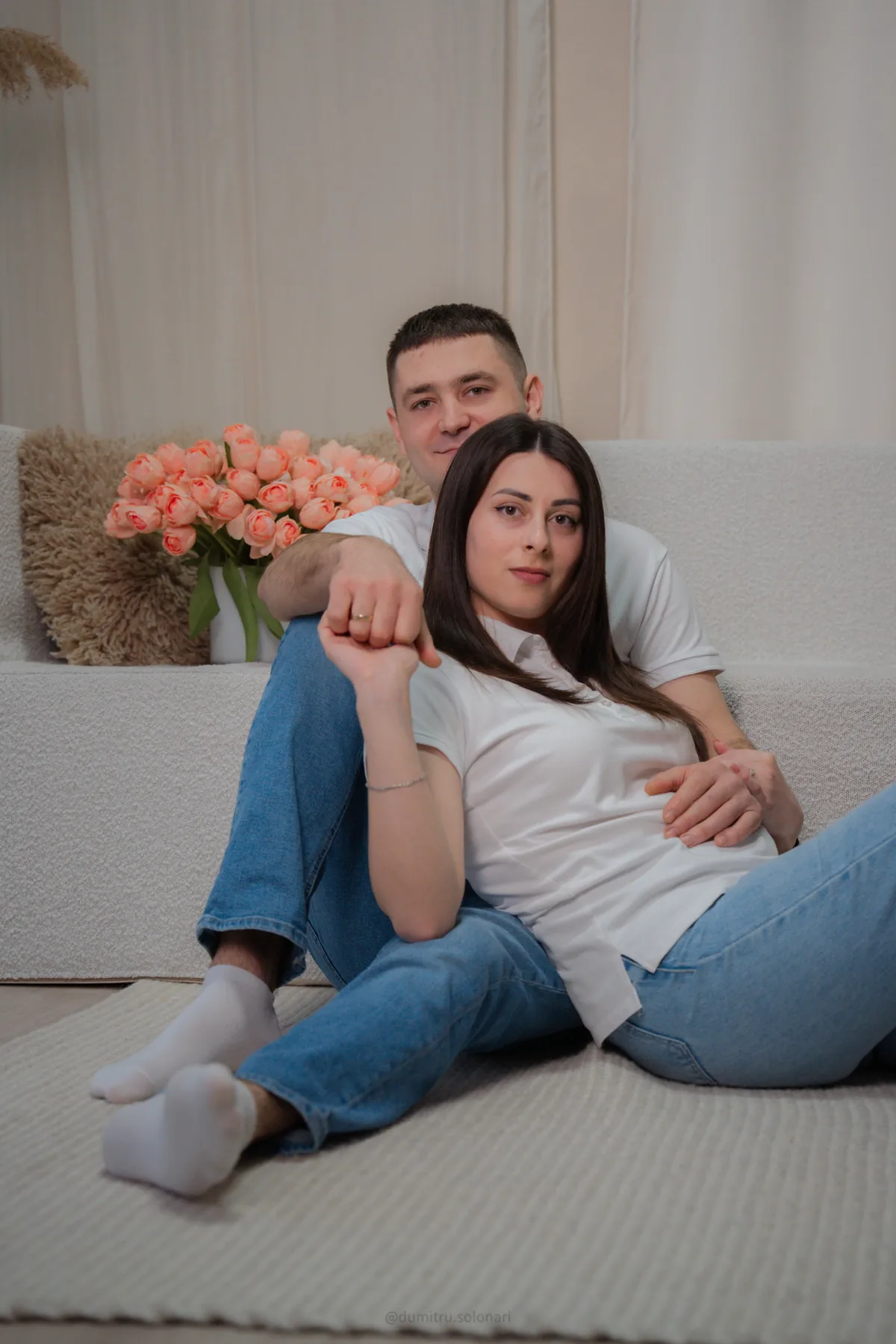 Alexandra și Dumitru relaxați pe canapea, în alb și jeans