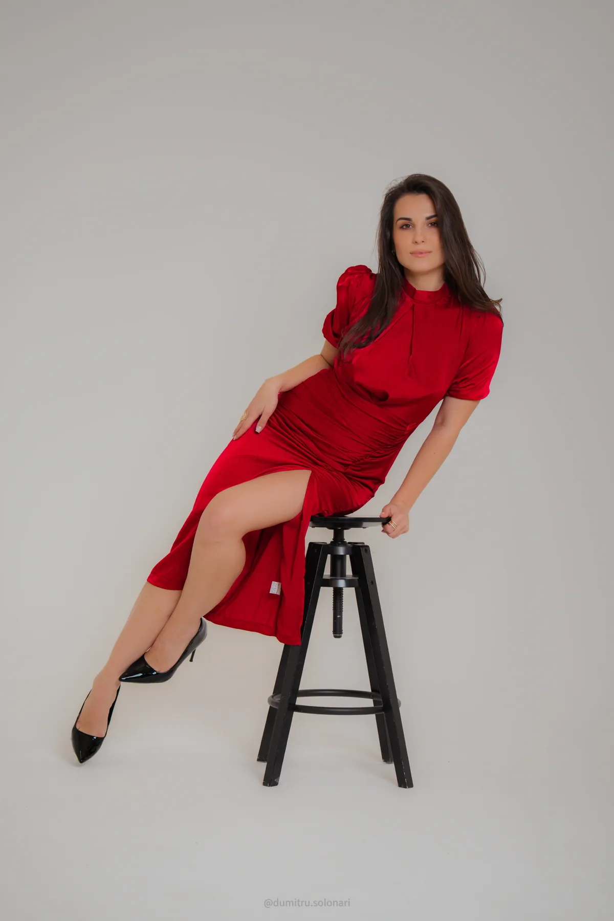 Alexandrina în rochie roșie, așezată pe taburet